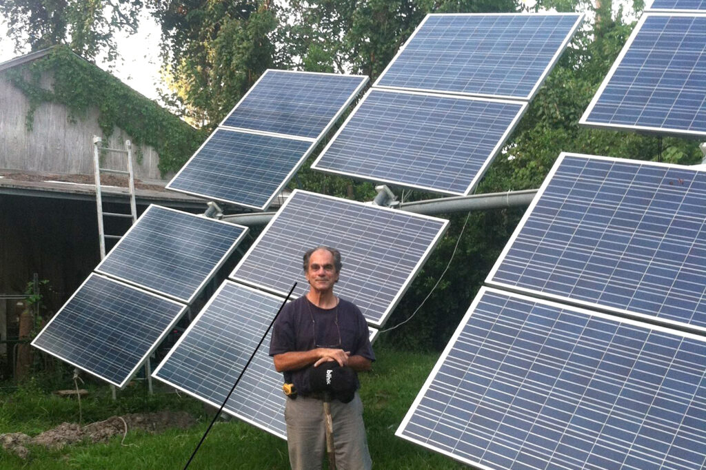 Bill Swann stands next to the solar power system he designed and built in his yard in Hilshire Village, Texas.