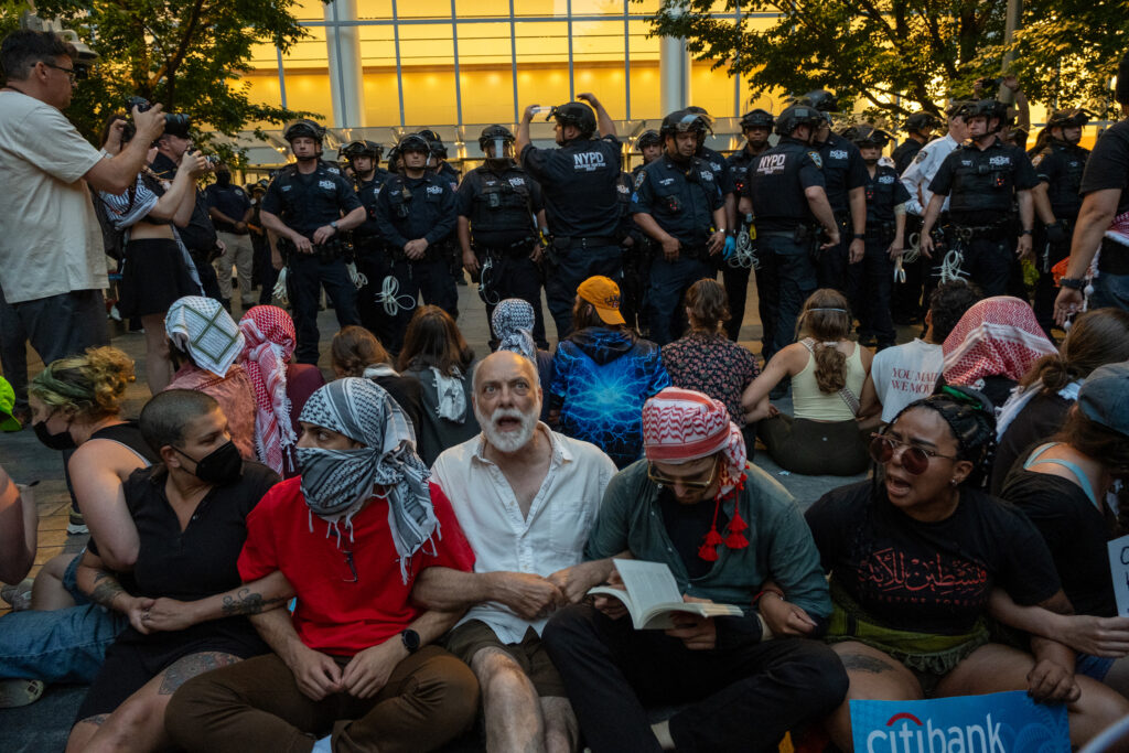 As the NYPD issued a dispersal order on Tuesday, 18 activists linked arms on the ground. Credit: Keerti Gopal/Inside Climate News