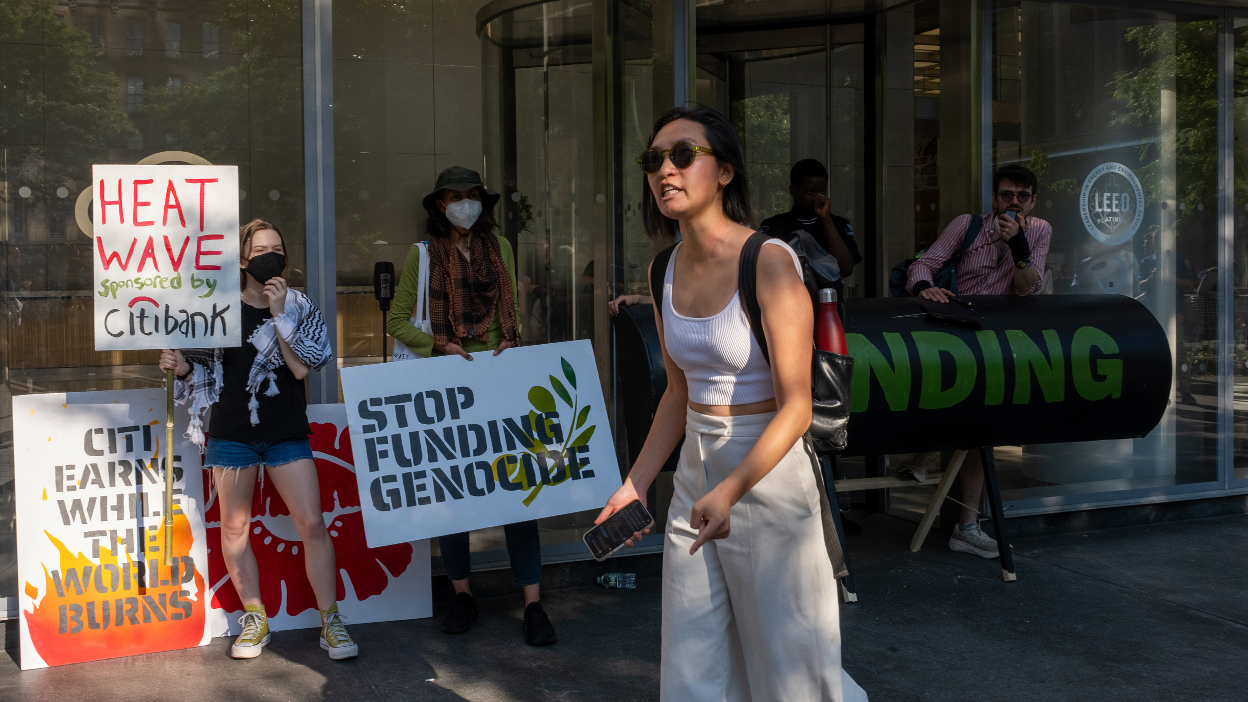 Alice Hu of New York Communities for Change, spoke to the crowd of employees waiting to get in the building about the campaign's demands for Citi. Credit: Keerti Gopal/Inside Climate News