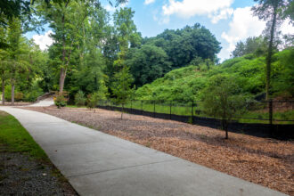 Part of the Bolin Creek Greenway in Chapel Hill, North Carolina, runs along a mound of coal ash behind a fence. Credit: Lisa Sorg/Inside Climate News