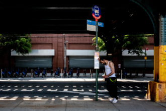 A person waits for the bus on May 22, 2022 in the Bronx borough of New York City. Temperatures in the metro area surpassed the 90 degree mark prompting heat advisories across the region. Credit: David Dee Delgado/Getty Images