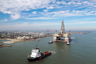 A tugboat tows a semi-submersible drilling platform into the Gulf of Mexico in Port Aransas, Texas. Credit: Tom Pennington/Getty Images