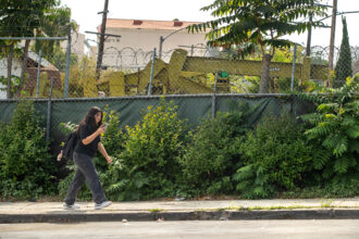 A student walks by an active oil drilling field located near Alliance Ted K. Tajima High School in Los Angeles on Sept. 27, 2023. Credit: Mel Melcon/Los Angeles Times via Getty Images