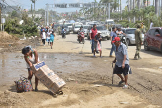 People walk down a damaged street in the aftermath of Hurricane Otis in Acapulco, Mexico on Oct. 28, 2023. Credit: Dassaev Tellez Adame/Xinhua via Getty Images