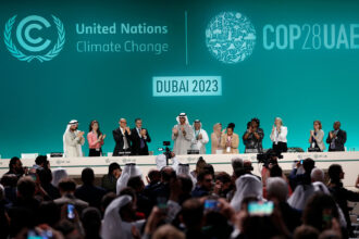 Attendees applaud after announcement of UAE consensus during a closing plenary of COP28 on Dec. 13. Credit: Wang Dongzhen/Xinhua via Getty Images