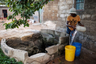 A boy collects water from a shallow well on Feb. 24, 2024 in Lusaka, Zambia. Credit: Luke Dray/Getty Images