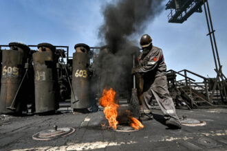 A worker sweeps around a furnace at a coke plant in Zaporizhzhia, Ukraine on April 11. Credit: Ukrinform/NurPhoto via Getty Images