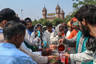 Volunteers distribute cold drinks at a heat wave relief camp on May 31 in Lahore, Pakistan. Credit: Arif Ali/AFP via Getty Images