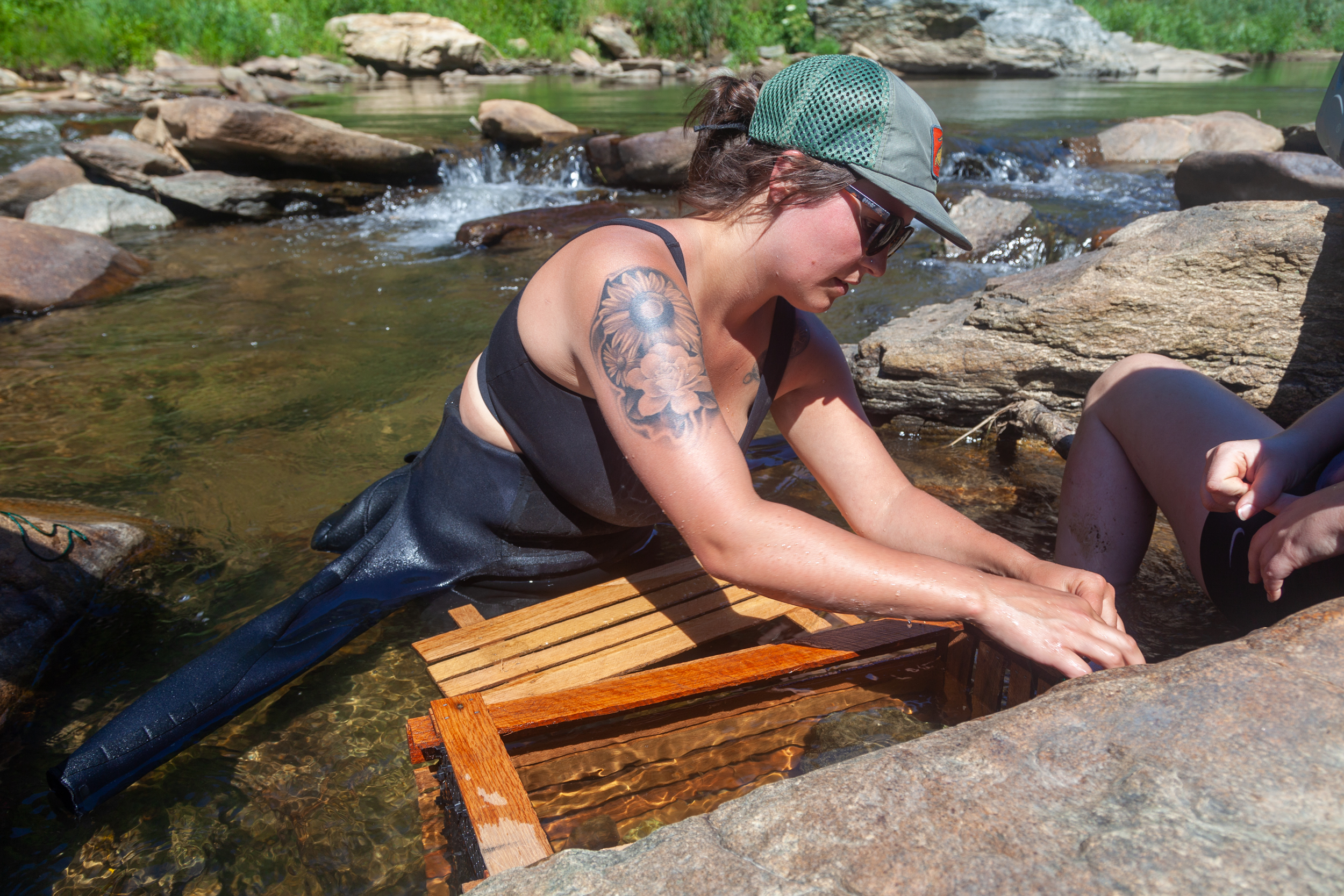 Hannah Woodburn, a staff scientist and community organizer at MountainTrue, prepares a temporary home for relocated Eastern Hellbenders in a separate part of the Watauga River.