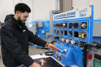 Muhammud Abu-Kass demonstrates how to work the training equipment at Guilford Tech Community College. The equipment trains him to be ready to work at Toyota’s first and only battery manufacturing plant in the U.S. Credit: Nicole Norman/Medill News Service