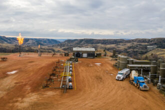 Natural gas is flared at a gas compressor station in the Badlands of North Dakota outside the Fort Berthold Indian Reservation on Oct. 30, 2021. Pipeline capacity issues in the state are a primary reason for flaring, according to Loren Wickstrom, field manager of the Bureau of Land Management’s North Dakota field office. Credit: Isaac Stone Simonelli/Howard Center for Investigative Journalism