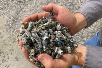 Jay Schabel, president of the plastics division at Brightmark, holds plastic pellets in his hand the company's new chemical recycling plant in northeast Indiana at the end of July. Credit: James Bruggers