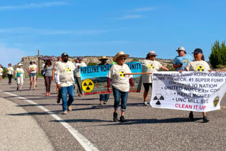 Residents and supporters walk southbound on New Mexico Highway 566 to the defunct uranium ore processing mill during the event on July 13 to remember the Church Rock uranium spill. Credit: Noel Lyn Smith/Inside Climate News